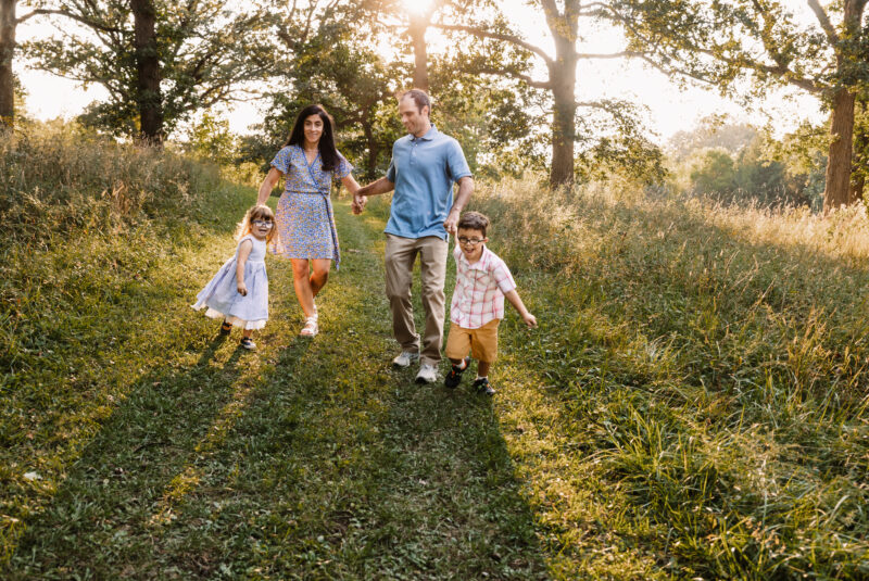 New Lenox family walking through a path in the forest at their fall family photo session in Joliet IL