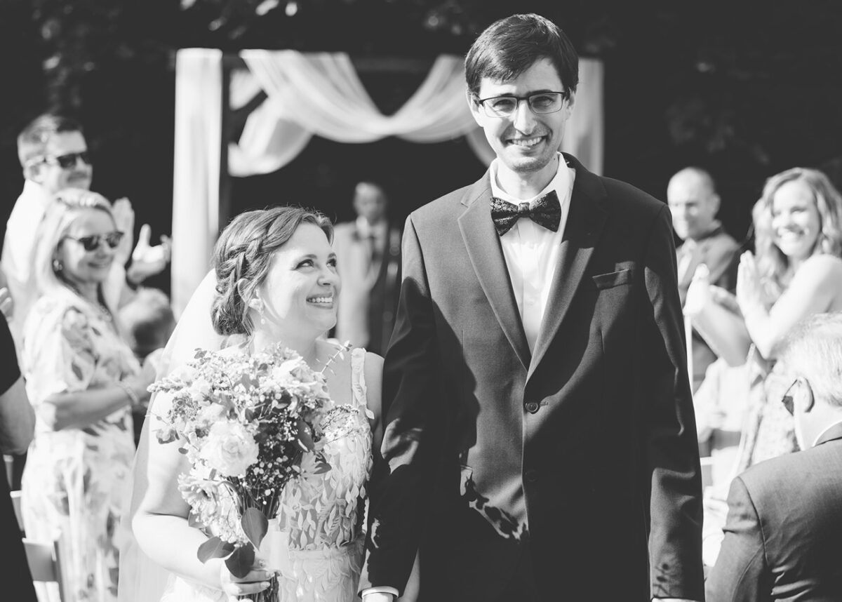 An adorable bride and groom as they come down the isle in their new lenox backyard wedding