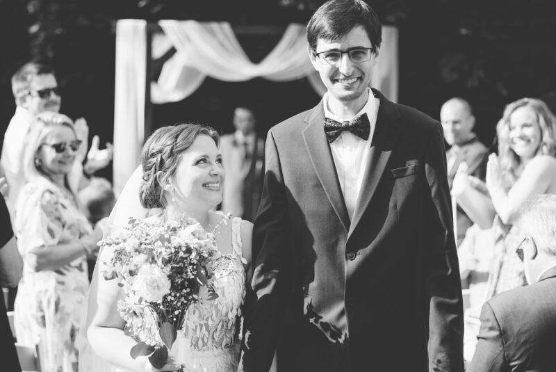 An adorable bride and groom as they come down the isle in their new lenox backyard wedding