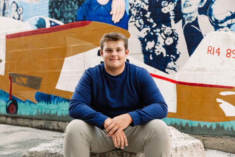 Marist High School Senior sitting in front of painted mural for senior photos